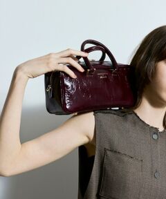 【allureville  2024 autumn&winter】<br><br>シワ加工のある柔らかいエナメルレザーを使用し、ツルっとしたエナメルよりも表情のある見た目も特徴の横長ボストンバッグ。<br>雨なども気にせず使用でき、お手入れも簡単にして頂ける人気の素材です。<br>新鮮な横長シルエットのボストンバッグは、ダブルファスナーで、口元が大きく開き、出し入れもしやすく、500mlのペットボトルや折り畳み傘なども収納可能です。<br>取り外し可能な太めのショルダーストラップもアクセントですが、ギボシで長さ調節をして頂けるので、ボディクロスにも、ショルダーにもスタイリングに合わせて調節していただけます。<br><br>※ショルダーベルトはサンプルになります。長さ調整ができるものに変更になります。<br><br>※照明の関係により、実際よりも色味が違って見える場合がございます。<br>またパソコン・スマートフォンなどの環境により、製品と画像のカラーが異なる場合もございます。<br>予めご了承ください。