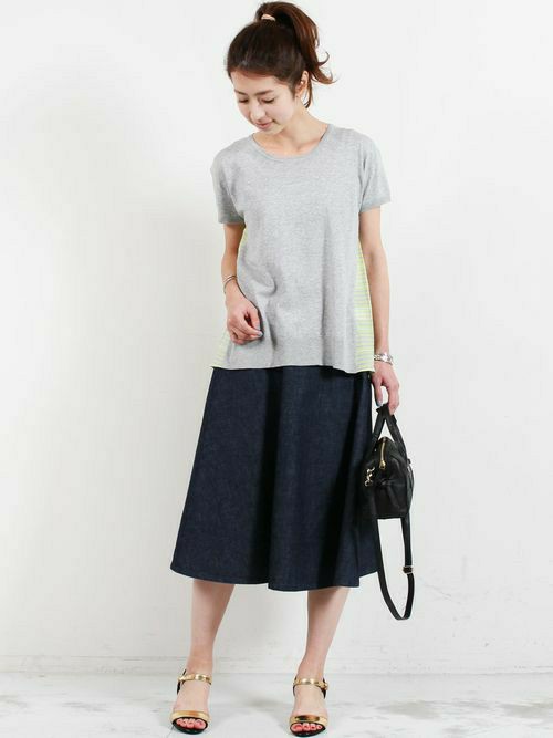 ストライプコンビのデザインニットをアクセントに、フレア型のデニムスカートを合わせた着こなし。