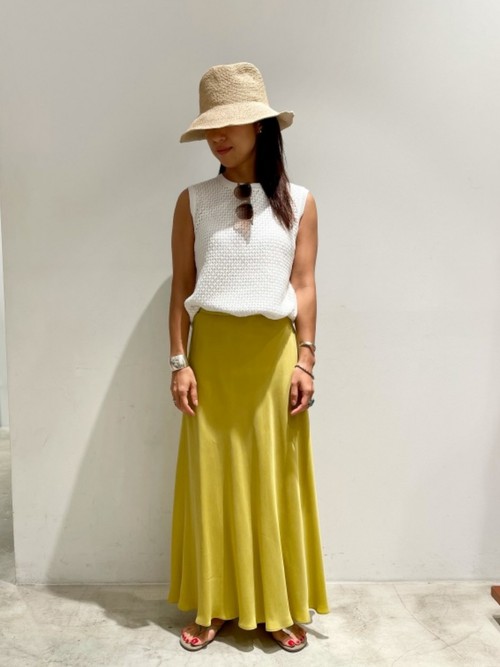 ビタミンカラーのイエローのスカートで明るい印象に。透かし編みのノースリーブニットとスカートでフェミニンコーディネートにしました。