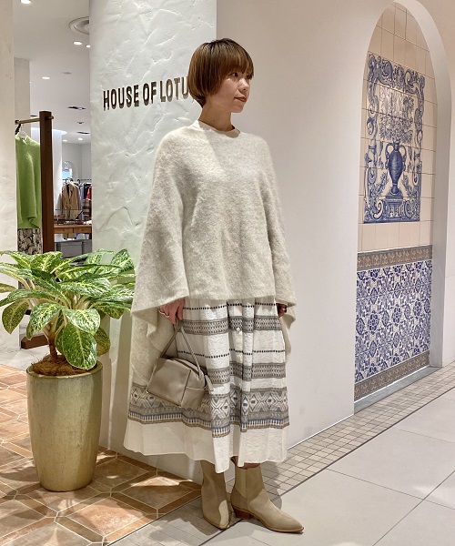 幾何柄をボーダー状のジャガード織りで表現したワンピース。ウエストに内蔵されているひもを絞ってボリュームを調整すると小柄な方もバランスよく着ていただけます。上からまとったポンチョもホワイトをチョイスして優しく温かみのあるウィンターホワイトのコーディネートに。