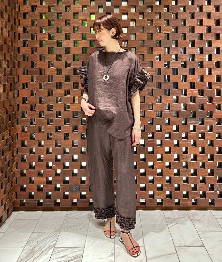 定番人気のリネンフリルシリーズに新色のブラウンが登場！優しく温かみのあるカラーをリネン素材で清涼感溢れる着こなしに。ブラウスとパンツのセットアップスタイルもおすすめです。

ブラウス：着用サイズ/2(M)
パンツ：着用サイズ/2(M)
身長:164cm