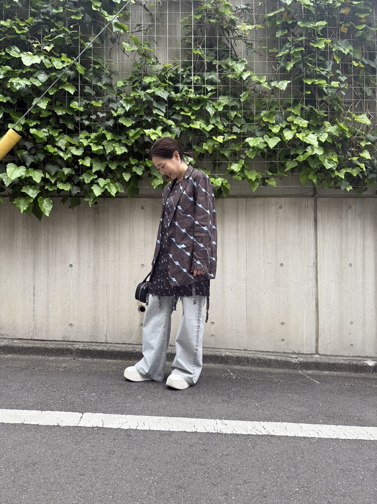 ジャケット：一重仕立てのリネンジャケット。アーバンな要素をグラフィカルに表現したインパクトのあるデザインが、スタイリングに個性をプラスします。さらっとしたリネン特有の風合いで、春や秋の端境期にぴったりの一着です。軽やかで着心地も快適。ドレス：幾何学柄が目を惹く、プリーツワンピースドレス。折り目の方向を巧みに切り替えることで、立体感のあるボーダーのような表情を演出。そこにあしらったテープディテールが、モダンで洗練されたアクセントを添えています。他にはない存在感を放つ、JNBYらしさあふれる一着。デニム：肌触りの良いフロッキー加工が魅力のデニムパンツ。コットンを基布に、表面にはベルベットのような光沢を生むビスコースのフロッキー加工を施しました。洗い加工による立体感のあるウォッシュフェード効果で、ヴィンテージ感漂う独特の風合いを実現。柔らかく暖かな生地で、快適な着心地とリッチな見た目を両立しています。ワイドレッグとルーズフィットのシルエットは体型をカバーしつつリラックス感をプラス。オーバーサイズデザインでユニセックスにも対応し、季節を問わず活躍する万能アイテムです。staff :165㎝, jacket 15179049 38(Mサイズ), dress 15179075 38(Mサイズ), denim 15179007  38(Mサイズ)