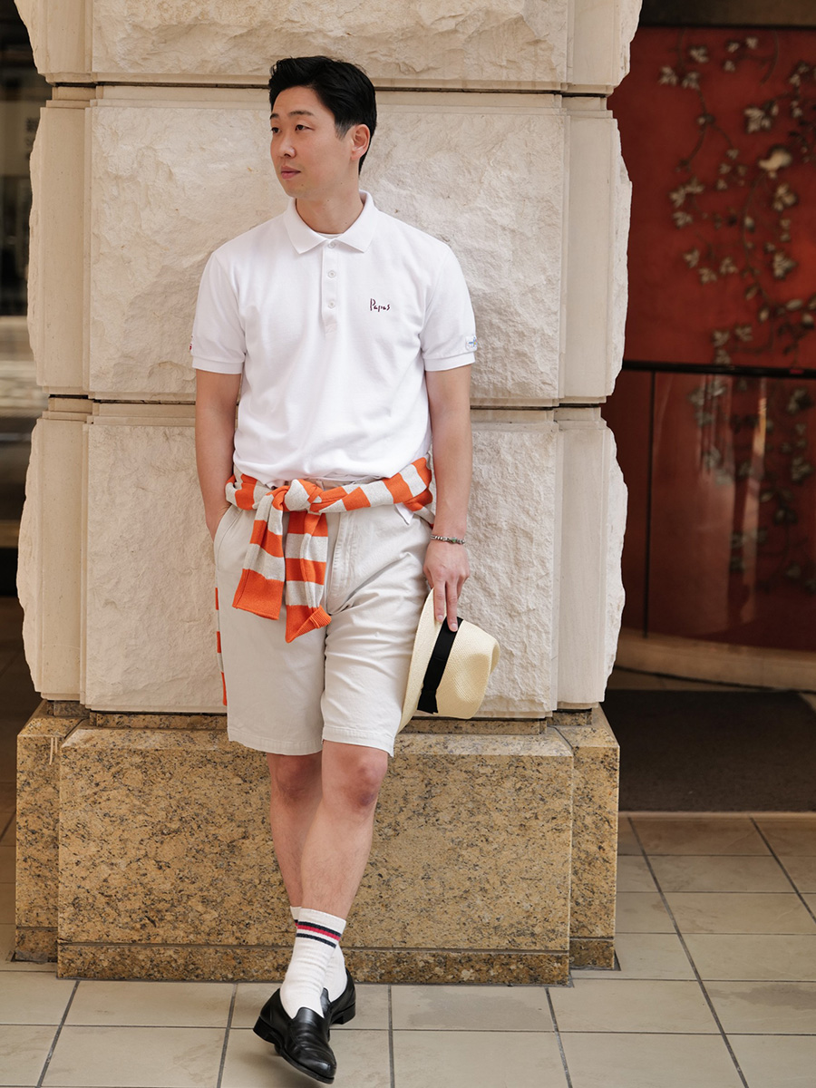 ボタンを一番上まで閉じた真っ白のポロシャツとショート丈のチノ、そして白いソックスにブラックのローファー・・・。こんなジャストサイズで着こなすアイビースタイルにも似合うという事実は、パパスにとっては新しい発見。ニットパーカーを腰に巻くというアイデアも、ぜひ取り入れてみたい。