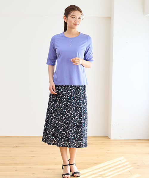 ラベンダーカラーのTシャツに同系色の柄スカートを合わせた女性らしい着こなし