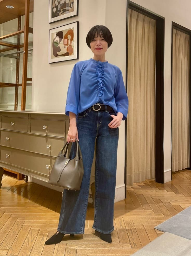 身長156㎝　〈ポリエステルウールボイルフリルブラウス〉
軽やかなボイル素材は、強撚糸によるさらりとしたタッチと程よいハリ感が魅力です。コンパクトな着丈で、インせずともバランスよく着こなせるのもポイント。
フロントにあしらわれた立体的なフリルが女性らしさを引き立て、デイリーコーディネートに華やかさを添えます。