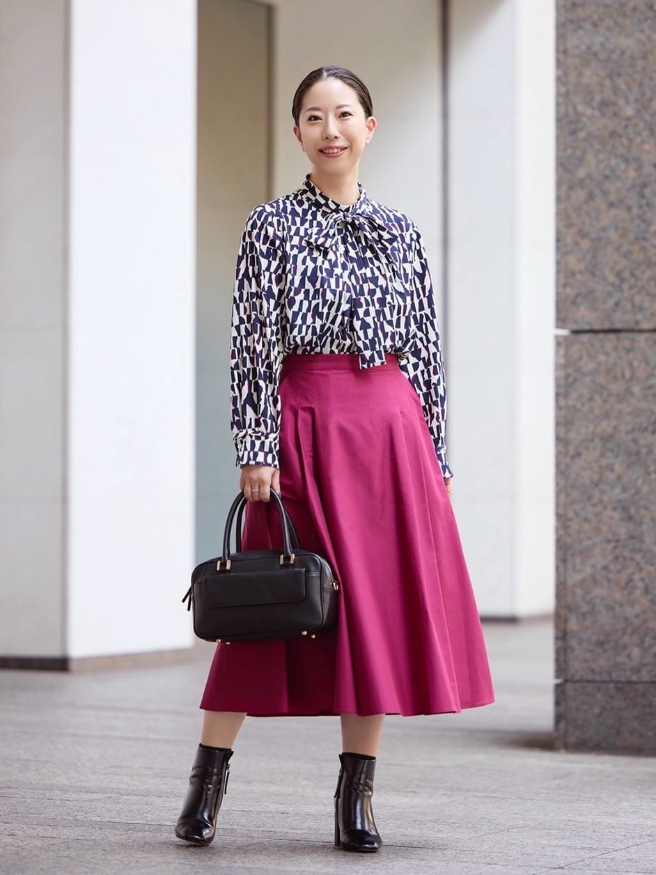 ビビットな配色が目を引く幾何柄のブラウスに、ローズカラーのスカートを合わせて秋の雰囲気を出しました。小物でブラックを効かせて大人可愛いスタイリングに◎【モデル身長：155cm】