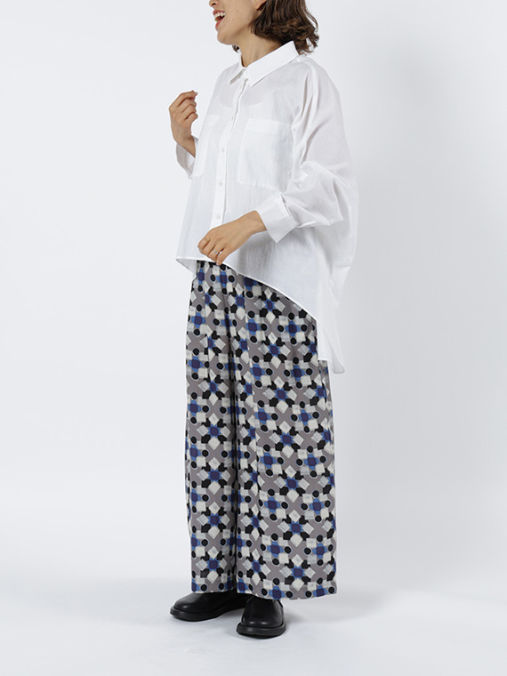 タイルのようなキカ柄のリラックスパンツをシロのシャツとシンプルに合わせたコーディネートです。シロのシャツはゆるっとしたシルエットと前より後ろが長いイレギュラーなヘムラインが特徴のこだわり満載のアイテムです。
モデル身長：162cm