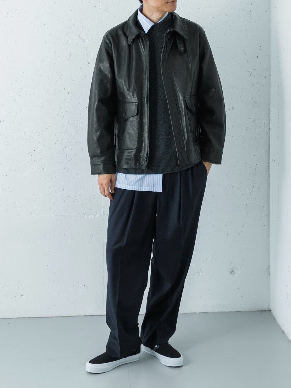 重厚感のあるレザーA-2ジャケットを軸にチャンキーニットとスクエアカットシャツをレイヤード。

上品なギャバジンパンツで全体を整えつつ足元はスリッポンで抜け感をプラス。