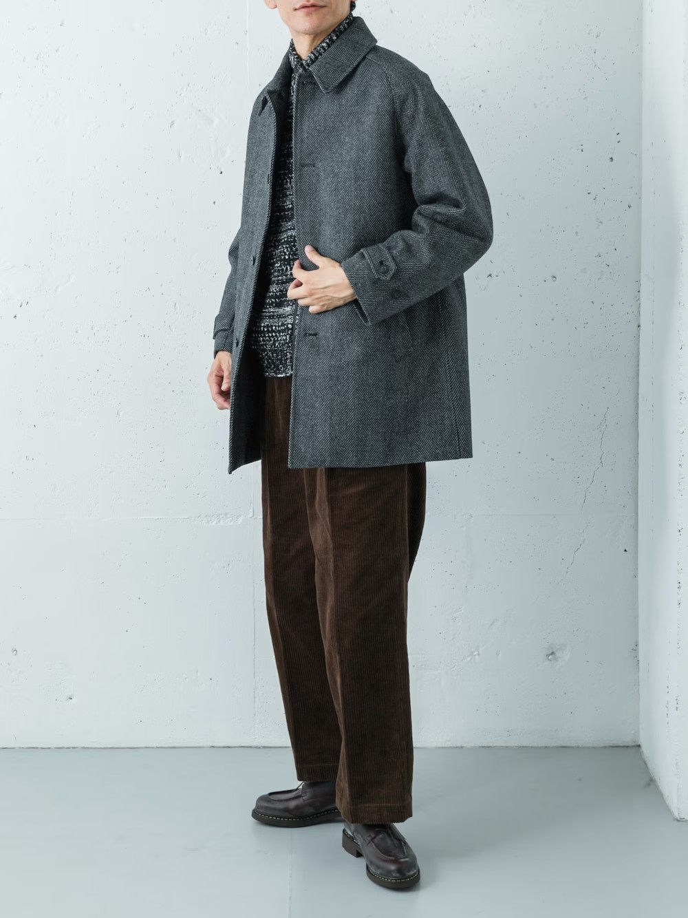 防風性を備えたツイードコートにマルチボーダーのニットを差し込み、コーデュロイトラウザーで季節感を引き立てたスタイル。