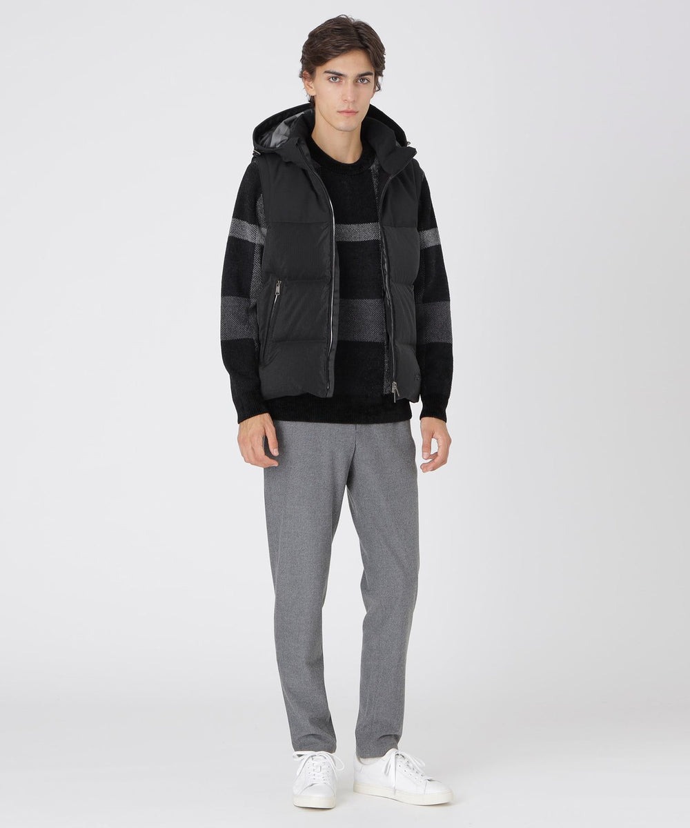 異なるふたつの素材を組み合わせることでスポーティーなデザインに仕上げたダウンベスト。フード取り外しが可能な2WAY仕様。表地にはワッシャー仕上げリップストップナイロンを使用。非常に軽量かつシワ感のある仕上げ加工を行うことで表面に陰影が生まれ、深みのある光沢を生み出しています。