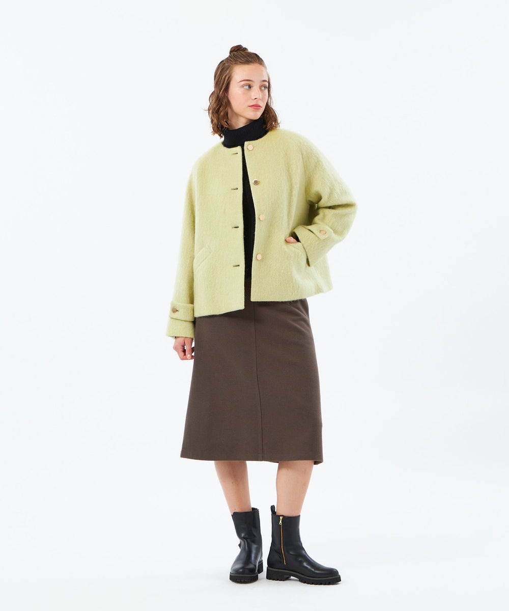 ケープのような柔らかいフォルムとゆとりのある袖がアイコニックなWELBURYノーカラーのSHORTモデル。毛足の長い上品なシャギー素材とフロントのゴールド釦がリュクスな印象です。手を入れやすいポケットやどんなボトムス、ワンピースともバランスよくコーディネイトしやすいレングスです。