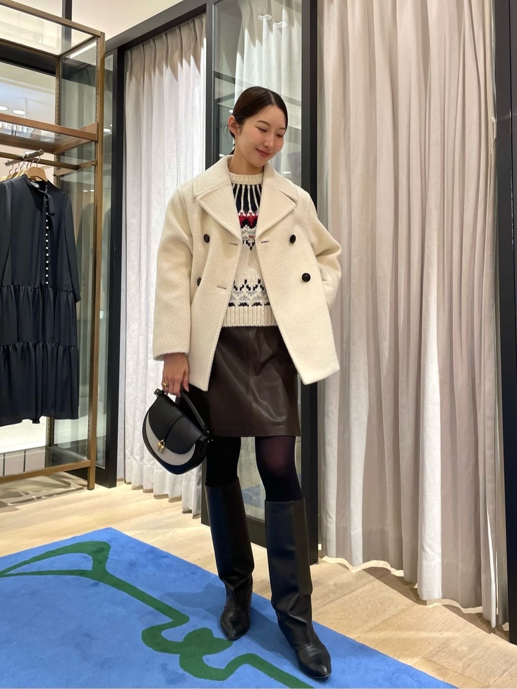 身長164㎝　大きな襟と少し起毛感のある生地が特徴的な〈TOMORROWLAND collection〉のコートは王道なデザインながらもスタイリングの主役になる華やかな1着です。

やや丸みがあり可愛らしいフォルムに合わせて、スカートと柄ニットで少しガーリーさのあるスタイリングに。

上質なレザーのスカートは、引き続きトレンドのミニ丈で登場しています。
カラーは深いブラウンでカジュアルにも馴染みが良く、色のコントラストが強すぎないのでトップスにビビッドなカラーアイテムを持ってくるのもお勧めです。