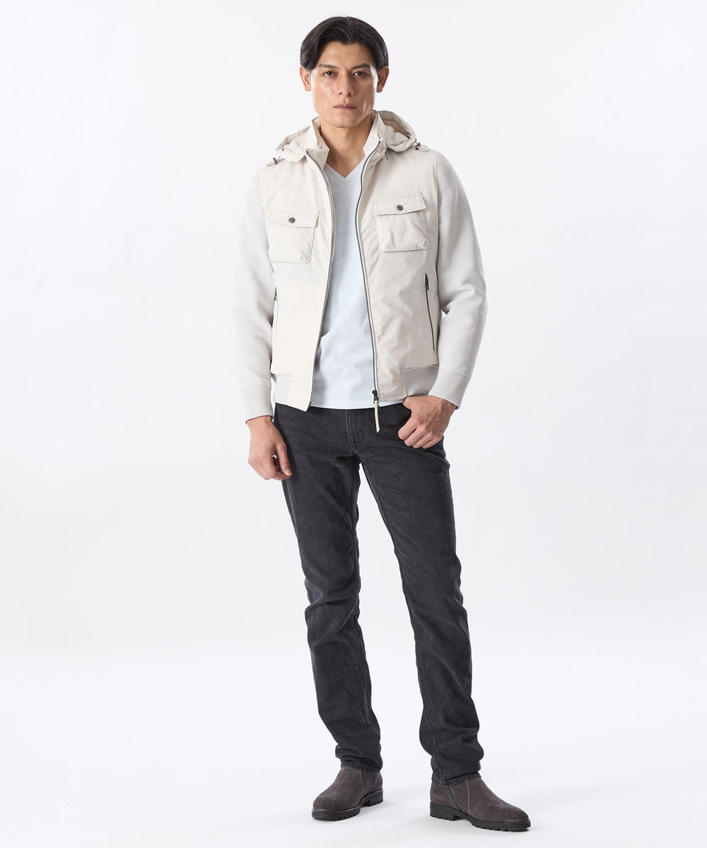 ダウンの暖かさとニットで動きやすさを兼ね備えたコンビダウンブルゾンで、フード取り外し仕様にすることで汎用性の高いアイテムに。身頃・フードにはダウンを入れたしなやかで適度なハリ感のポリエステルツイル生地、袖にポリエステルニットを使用。