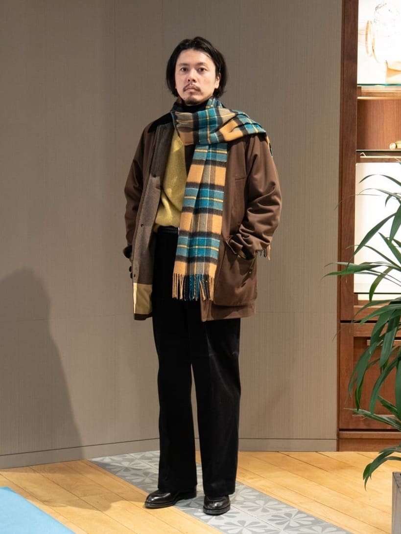 身長178㎝　イタリア SONDRIO社のDALSASSOコレクションから、撥水加工を施したコットン・ウールのキャバリーツイルを使用したコートをご紹介。
フィールドコートと呼ばれるハンティングアウターをベースに、大きめの腰ポケットなどバッグ要らずのディテールも魅力です。

ブラウンのコートにイエローのシャギーニットを合わせて、現代的なドラッドスタイルを表現しました。
インナーのタートルネック、パンツとシューズはブラックで締めているのがポイントです。