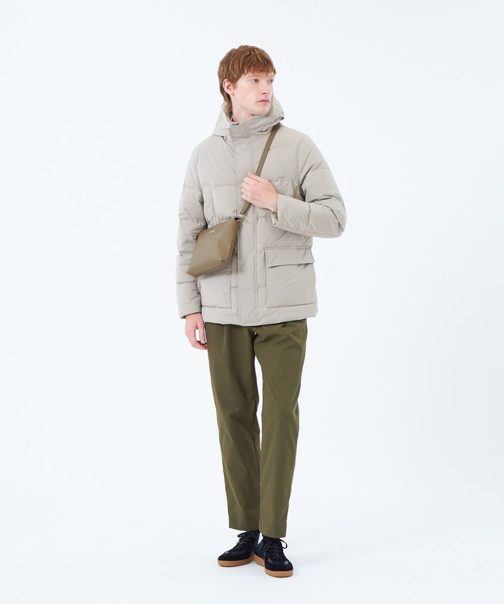 スタンドカラーにフードが付いた様な立体的なフードデザインとコンパクトな肩回りがスタイリッシュに演出してくれます。身頃中央付近はダウン分量を多く、上下端の方はダウン分量を少なく調整する事により、暖かさを保ちながらスッキリとした見た目を実現しました。