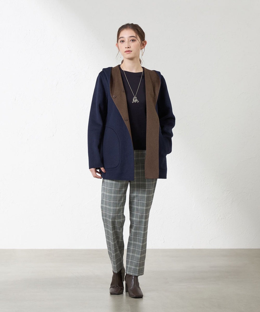 両面配色の紡毛リバーコート。片面に鮮やかな色を配し、フードからのぞくその配色がデザインポイントになっています。リバーシブル仕立てで、どちらの配色で着用しても着映えする主役級のコートです。