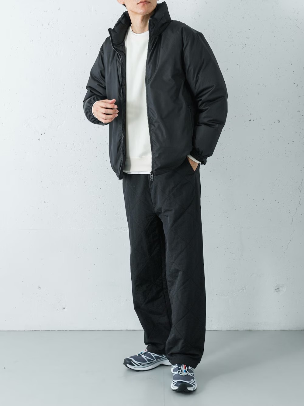 軽量なTAION別注のダウンジャケットに、ハリスツイードポケット付きのスウェットプルオーバーを合わせ、素材のミックスを楽しむカジュアルレイヤード。
ボトムスにはキルティング中綿のイージーパンツを選び、上下ともリラックス感と暖かさを重視した機能的なスタイルに仕上げました。