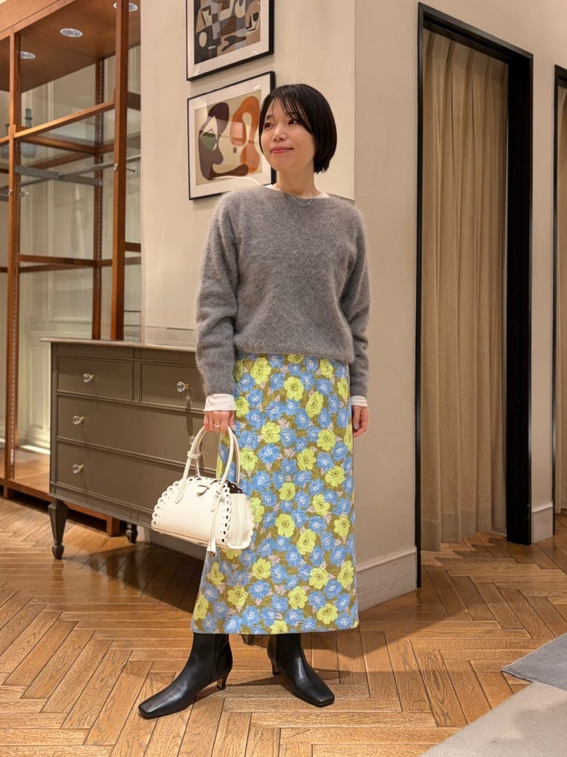 身長156㎝　柔らかなグレーのニットに、華やかなフラワージャカードのスカートを合わせた、大人のフェミニンスタイル。

ニットは程よくコンパクトなシルエットで、柄スカートを引き立てながら全体をすっきりとまとめてくれます。

アウターには、上品なベージュのスタンドカラーコートをプラス。
本来はワンサイズ下がジャストサイズですが、あえてSサイズを選び、ゆったりとしたシルエットで着用しています。
程よいゆとりがあるため、中にニットを重ねても窮屈感がなく、レイヤードもしやすいのが魅力です。
シンプルでミニマルなデザインが、柄アイテムとも好相性で、きれいめにもカジュアルにも振れる一着です。
