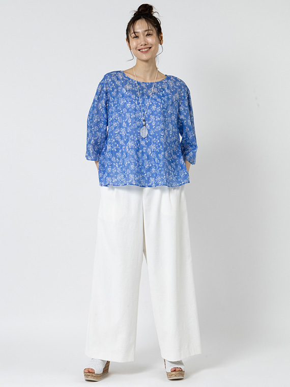 デコルテを美しく見せ、夏らしい開放感を与える浅くて広めのラウンドネックのブラウスに、さわやかなドライオックスのシロのワイドパンツを合わせたコーディネートです。ふんわりとしたボリューム袖がマニッシュになりがちな更紗柄に、ほんのりと可憐でガーリーなスパイスを添えてくれます。
モデル身長：165cm