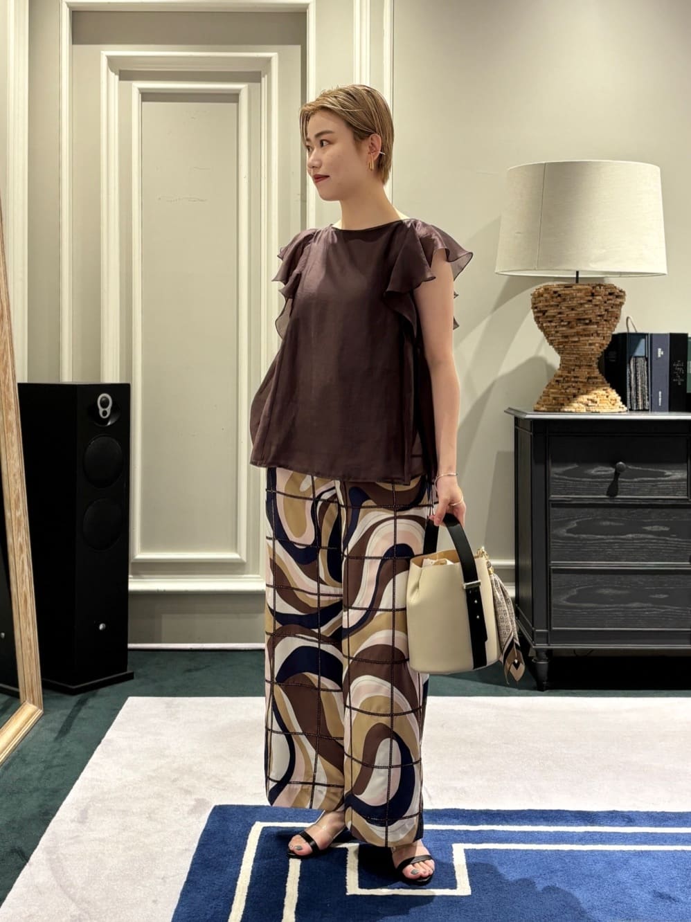 身長162㎝　〈Ballsey〉セルロースポリエステルオーガンジー フレアスリーブブラウス

軽やかなオーガンジーの透け感に、シルクのような光沢と発色が特徴のセルロースを使用した華やなブラウスです。
オーガンジー特有の清涼感がありながらも、どこか奥行きを感じさせる質感が、装いをクラスアップさせてくれます。

シルエットは、ボディラインを拾わないゆとりのある設計。
肌に張り付かず風が通るため、真夏でも涼やかな着心地を叶えてくれます。
また、肩先をさりげなくカバーする袖ぐりのデザインは、ノースリーブに抵抗がある方にもぜひお試しいただきたいデザインです。

〈TOMORROWLAND collection〉アイレットウェーブプリント ワイドストレートパンツ

大胆な幾何学模様の上に、タッターソール柄の梯子レース刺繍を施した、マスターピースな一着。
ポリエステル100%でありながら、コットンシルク混のような上品な艶と、さらりとした落ち感・ハリを兼ね備えています。
この上質な素材にプリントと刺繍を重ねることで、大人のためのリラックスモダンなパンツに仕上がりました。