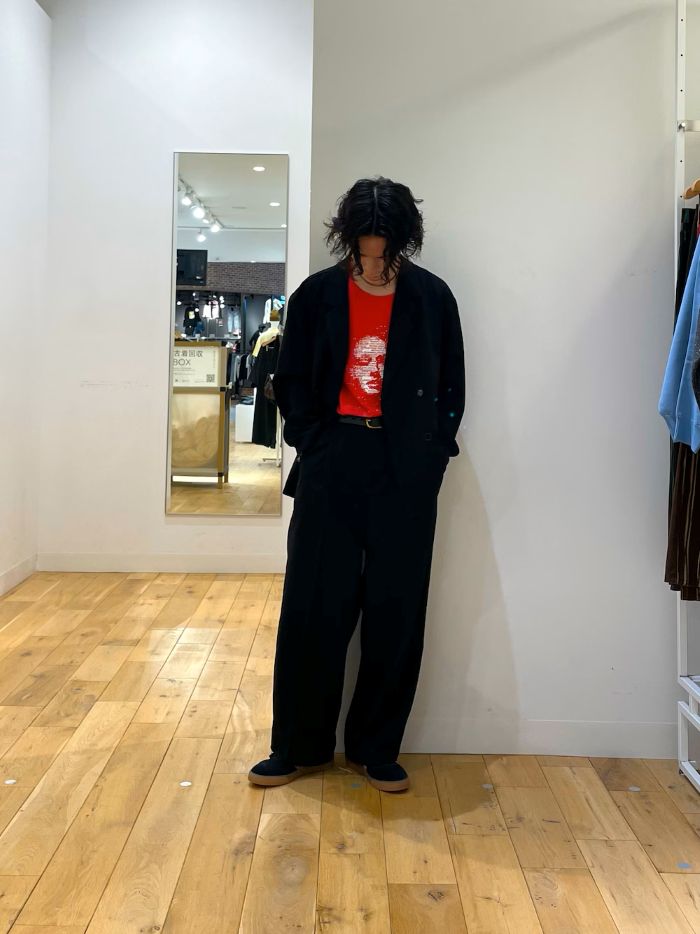 黒のセットアップに目を惹く赤のTシャツを差し込んだコーデ。足元にはひっそりとレオパード柄も。