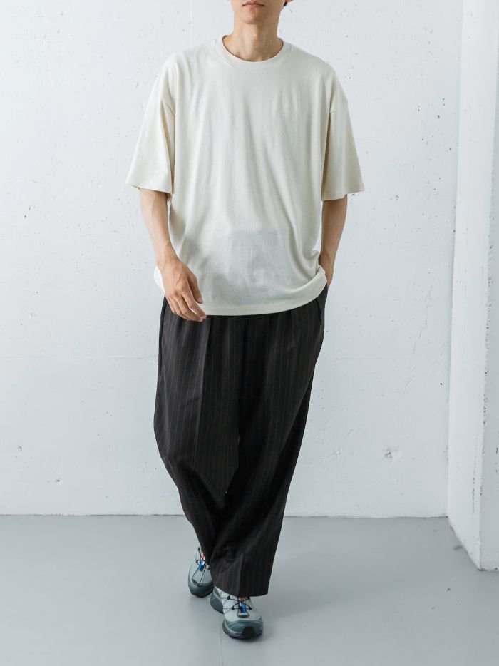 ボトムスには「TW STRIPE TROUSER」のブラウンをセレクト。クラシックなストライプ柄と上品なトラウザーの仕立てが、トップスのラフさを引き締め、縦のラインを強調した美しいシルエットを描きます。