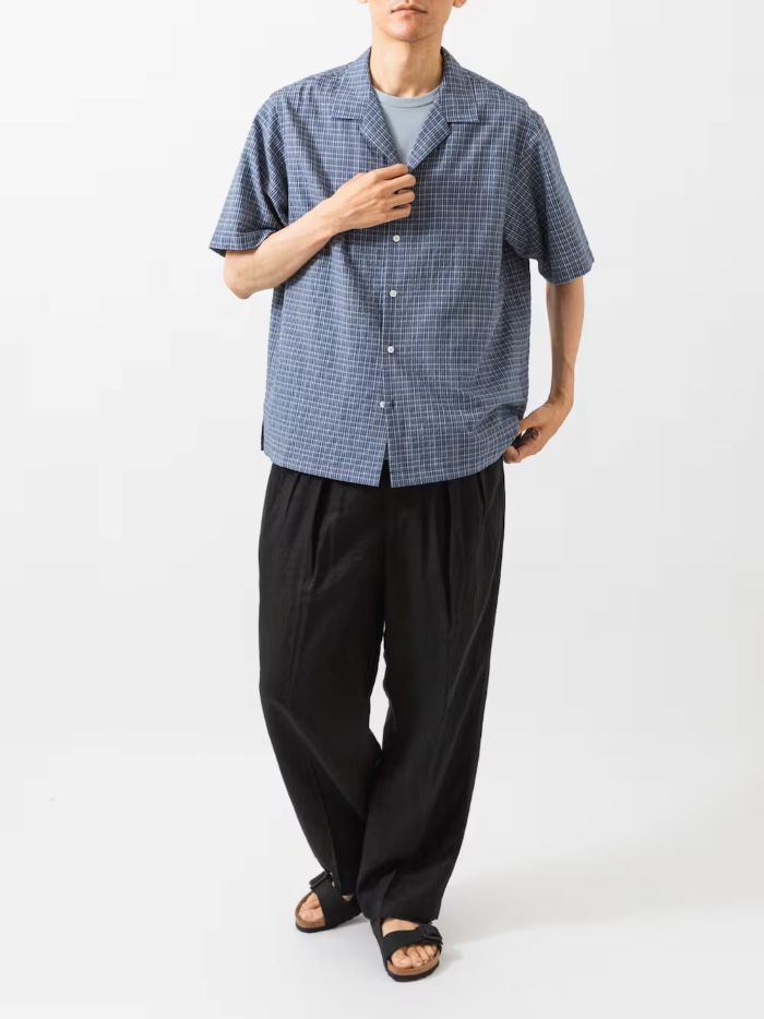 細かなチェック柄のネイビーシャツに、風通しの良い黒の「LINEN WIDE EASY PANTS」を組み合わせた、夏にぴったりの着こなしです。
上下ともにゆったりしたシルエットですが、ダークトーンでまとめることでラフになりすぎず、大人っぽい印象に。