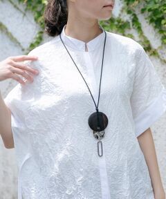 味のあるマホガニーカラーのウッドプレートにメタルパーツをコンビネーションしたデザインペンダント。縦のラインを強調しつつ、印象的なアクセントでスタイリングに変化を付けてくれるお洒落度の高いひと品です。ライトな紐タイプに仕上げ、スライド調節で楽に長さアレンジが出来るのも嬉しいポイント。オン・オフ問わずロングシーズン愛用いただける汎用性の高いアイテムです。