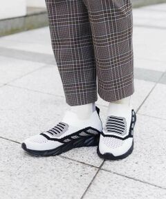 シックなモノトーンで表現した配色デザインが魅力的なニットスニーカー。スポーティーなスリッポンタイプながらもラインアクセントを効かせモード&スタリッシュに仕上げました。履き口リブ仕様で着脱しやすく、かかとはプルストラップ付きの機能的なお作り。軽やかなメッシュ素材でロングシーズン活躍してくれるおすすめのひと品です。