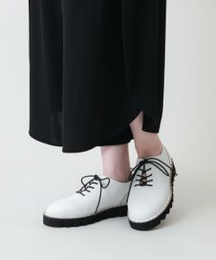 ラウンドトゥ×ボリュームソールがお洒落なデザインシューズ。配色コードとラインでアクセントを効かせたスタイリッシュなひと品です。波型カットでオリジナリティを際立たせたソールディテールもこだわりのポイント。ラウンドトウだから圧迫感もなく履き心地も抜群。靴紐もゴムなので解かずに脱ぎ履きしていただけます。フォーマルからカジュアルな着こなしにも合わせられるシンプルなカラーリングも魅力的なおすすめアイテムです。