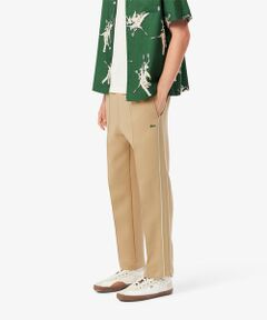 セール】 『Lacoste x Netflix』 耐水総柄トラックパンツ （チノ