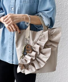 —25AW—<br><br><b>トレンドのチャームがセットになった、使いやすさと遊び心を兼ね備えた2WAYトートバッグ</b><br><br>ポリエステル素材で甘くなりすぎず、大人の女性にもぴったりなフリルトートバッグ。<br>程良いフリルデザインがコーディネートのアクセントになり、ショルダー付きで手持ち・肩掛けどちらも楽しめる仕様です。<br>しっかりとマチがあり、デイリーに必要なアイテムがしっかり入る収納力もポイント。<br>内ポケットも備えており、鍵やリップなど小物類の整理にも便利です。<br><br>■お問い合わせ品番：310-00-1281<br><br>▼シリーズもございます。<br>チャーム 付き フリル 巾着 ショルダー（品番：310-00-1280）<br><br><br>※生産状況により店舗にて販売する場合もございます。<br>※長時間日光に晒したり光熱のライト等に当てると変色、破損の恐れがございます。<br>※使用しているチェーンや金具類のメッキの耐久性については十分に注意しておりますが、年月と共に変化しサビ、剥がれ等、衣類を汚す場合もございます。ご注意くささい。<br>※持ち手を強く引っ張ったり物の詰め込み過ぎや、極めて重いものを入れて使用しないでください。破損の原因となります。<br>※コバ塗りをしているものは加工の特性上永久的なものではなく、徐々にひび割れ、脱落、べとつきが生じます、予めご了承ください。<br>※合成皮革部分素材の特性上、経年劣化が避けられません。使用の有無に関わらず、経年劣化は進行します。予めご了承ください。<br>※撮影環境により商品の色味が異なって見える場合がございます。商品のお色味は、物撮り画像をご参考にしてください。<br>※末永く愛用頂く為に、アテンションタグを必ずご確認の上、着用又はお取り扱いください。<br><br><font color="RED">※画像の商品はサンプルです。 </font><br>実際の商品と仕様、加工、サイズが若干異なる場合がございます。</p>